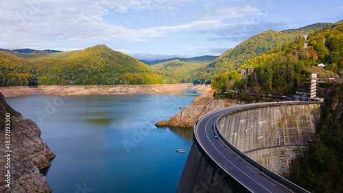 Aerial photography of Vidraru dam, in Romania. Photography was shot from a drone from above canyon at Vidraru lake with the dam and the lake in the view and mountains in the background.
