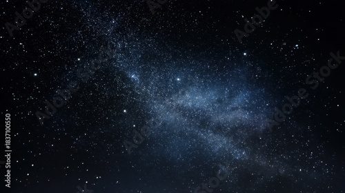 Bright stars and distant galaxies fill the night sky above. The dark landscape below contrasts with the shimmering celestial bodies. It is a clear evening perfect for stargazing.