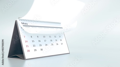 Desktop calendar animation with pages turning rapidly, showing the passing of a full year. Concept of time, deadlines, and schedules on a clean white background.