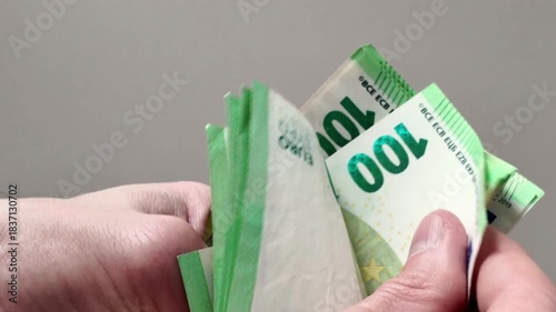 Hands count a large stack of hundred euro banknotes