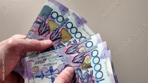 Close-up of counting a stack of ten thousand Kazakhstani tenge banknotes