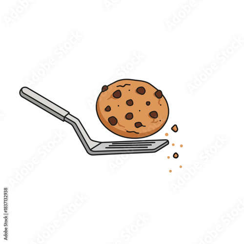 A freshly baked chocolate chip cookie is lifted by a metal spatula, showcasing baking and deliciousness