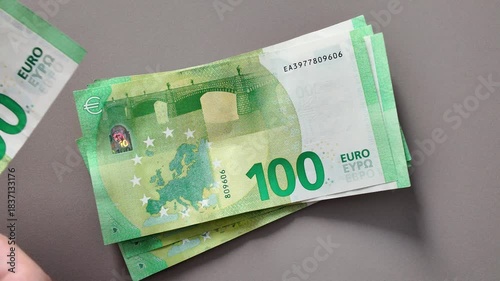 A man's hands count a stack of one-hundred-euro bills. The European concept of currency exchange and cash payments for business, finance, and economics