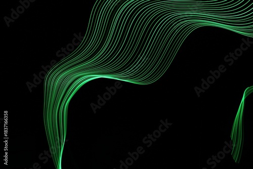 Long exposure light painting photography. Swirls of green light in parallel lines against a black background
