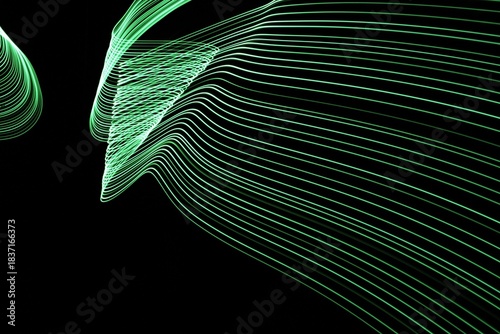 Long exposure light painting photography. Swirls of green light in parallel lines against a black background