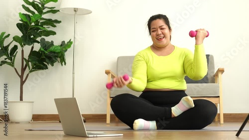 Focused Fitness: A woman, radiating determination, engages in an online workout with dumbbells, embracing the journey toward a healthier self.