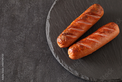 grilled sausages on dark slate panel, selective focus
