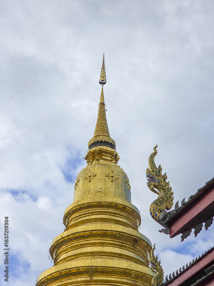 Fototapeta premium Majestic golden stupa standing beautiful buddhist temple Thailand, showcasing intricate asian architecture. Spiritual and religious pagoda offers serene experience, reflecting ancient heritage