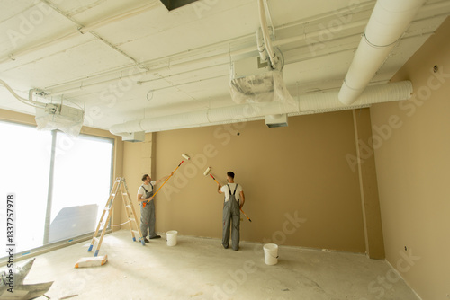 Two workers painting a brow...