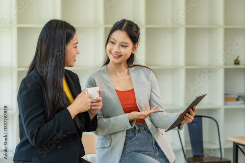 Portrait of two young businesswomen having a meeting or presentation and seminar standing in the office. Portrait of a young businesswoman talking.