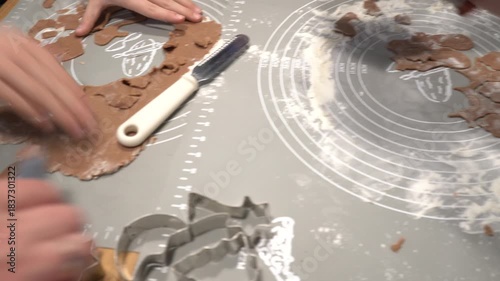 Making gingerbread cookies with cookie cutters on a baking mat