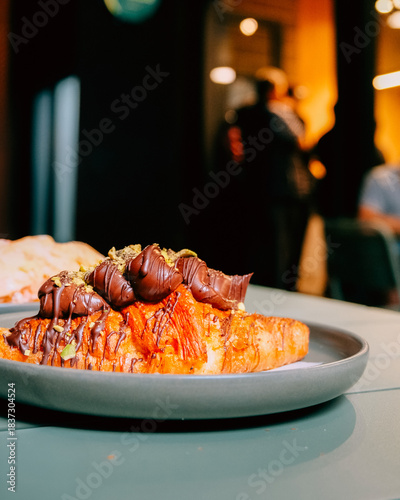 Chocolate topped croissant served on a plate, showcasing artisanal bakery products, café lifestyle, and modern dessert presentation. Publique bakery, popular tourist destination in Melbourne