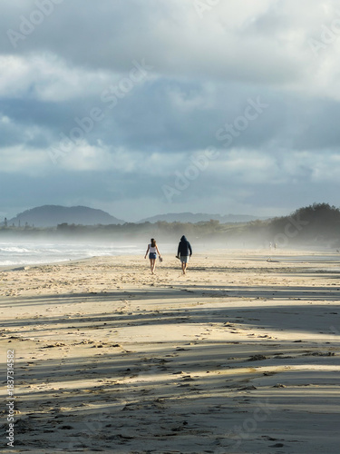 Couple walking on a misty beach
