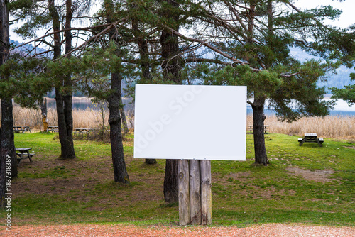 Blank White Sign on Wooden Posts in a Scenic Park