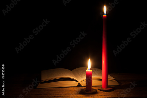 Soft candlelight flickers, casting a warm, orange glow on the open book. The rough wooden table breathes tranquility, while the quiet magic of the moment invites lingering and daydreaming.