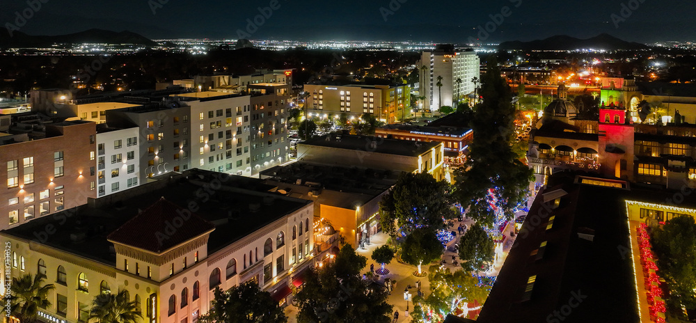 Fototapeta premium The Night Lights of Downtown Riverside, California from a UAV Drone Aerial view with the horizon in the background during the Christmas Holiday Season.