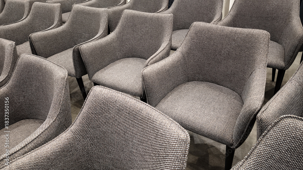 Fototapeta premium The conference room is ready: rows of modern gray upholstered chairs are lined up for a public event. This backdrop is ideal for conferences, presentations, and event planning.