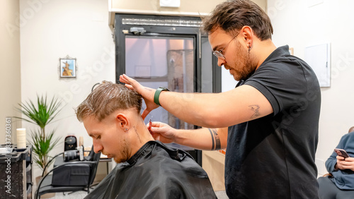 Barber giving a precise haircut in modern barbershop