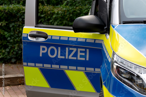 The open door of a German police car with the sign 