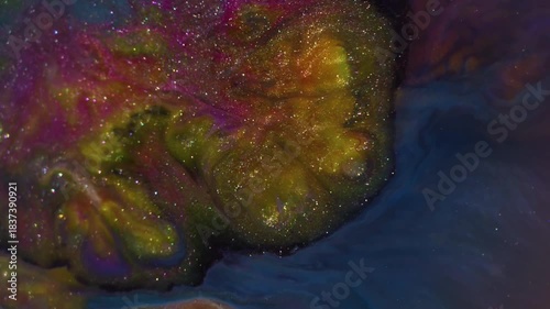 Blur glitter ink. Wet texture. Defocused golden blue pink colorful sparkling liquid floating on abstract art dark black background.