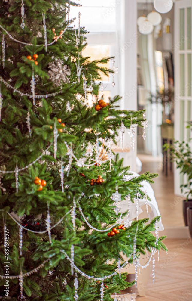 Fototapeta premium Vibrant decorations and glittering icicles create a festive atmosphere in the cozy room