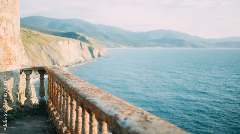 Obraz premium View of ocean and mountains from a stone railing near the coast