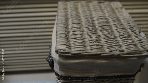 Sorting dirty laundry into a wicker basket at home