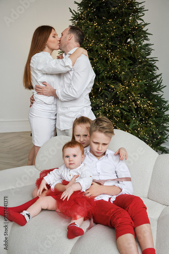 Family celebrating Christmas together in living room with festive decorations