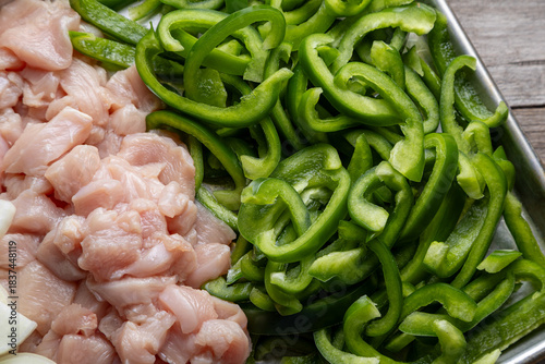 Sheet pan chicken fajitas with sliced onions, green bell peppers, and seasoned chicken arranged on a baking tray. Fresh, simple, and perfect for meal prep or easy dinner recipes.