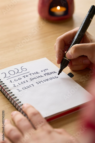 New year's resolutions. Vertical shot of hand starting 2026 goals indexed list in notebook