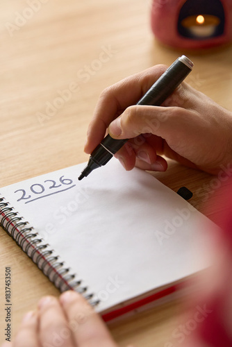 New year's resolutions. Vertical shot of hand writing 2026 text in notebook 