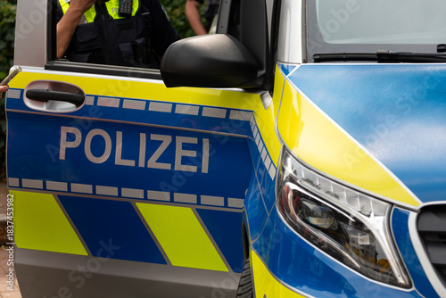 The open door of a German police car with the sign 