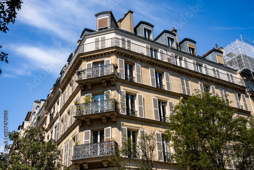 Glimpse of a typical and elegant residential building in Paris city center, France, with wrought iron railings and balconies.