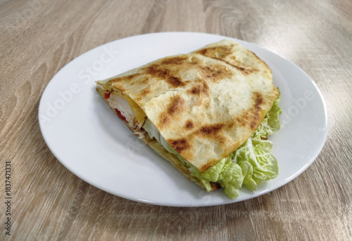 A freshly made crepe sits on a white plate