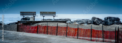 Selective focus Panorama of two benches overlooking the frozen waterfront of Lake Huron during the winter