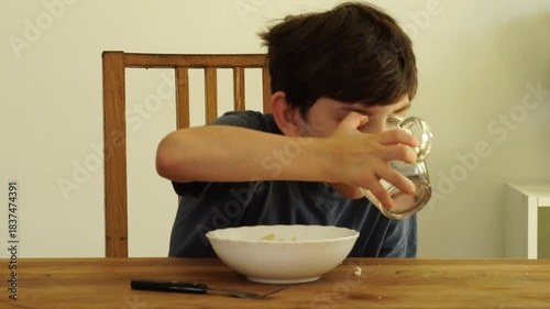 Boy eats noodles at the kitchen