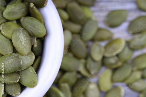 Pumpkin seeds in a wooden bowl on a wooden background
