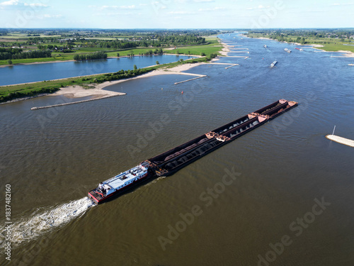 Aerial view of a pusher tug transporting coal on the Waal river to Germany, Rossum, The Netherlands