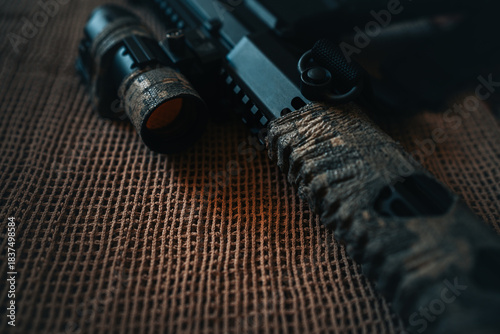 camouflaged rifle with a collimator sight