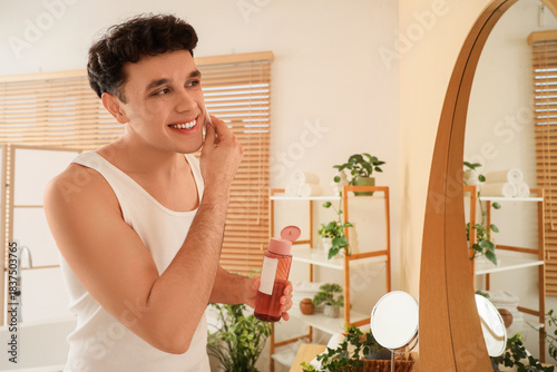 Young man cleansing his fac...