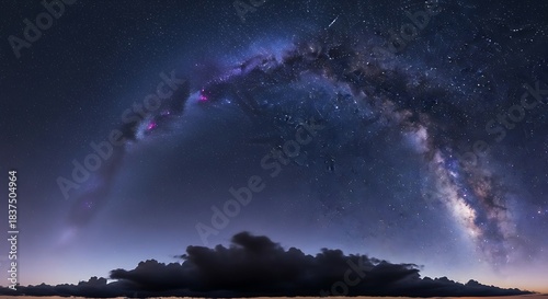 The majestic arc of the Milky Way galaxy stretching across a dark night sky above a silhouetted cloud formation and a glowing horizon.