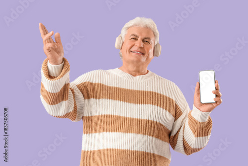 Senior man in headphones wi...
