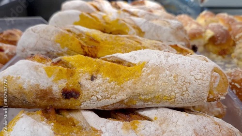 Bread roll filled with calabresa sausage on display in a Brazilian bakery.