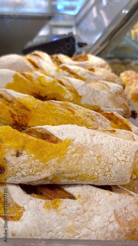 Bread roll filled with calabresa sausage on display in a Brazilian bakery_vertical.