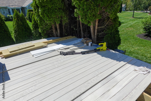 Partially constructed wooden composite backyard deck tools and planks