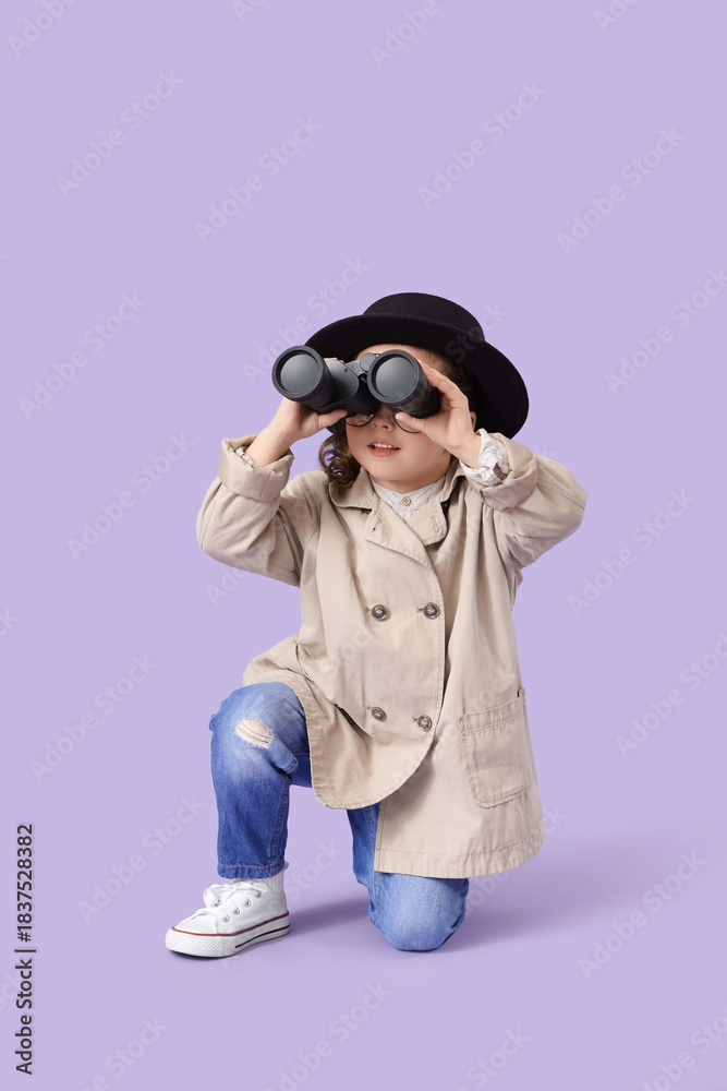 Fototapeta premium Cute little detective looking through binoculars on lilac background