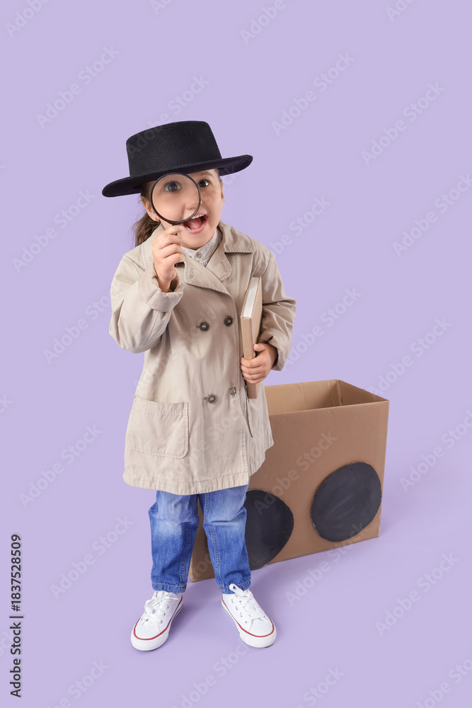 Fototapeta premium Cute little detective with adventure book and magnifier near cardboard car on lilac background