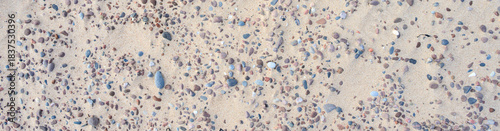 Photography Sandy beach with small pebble rocks in random patterns, as a nature background