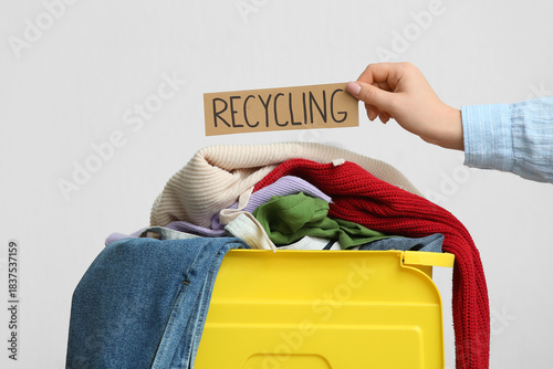 Woman holding RECYCLING sig...
