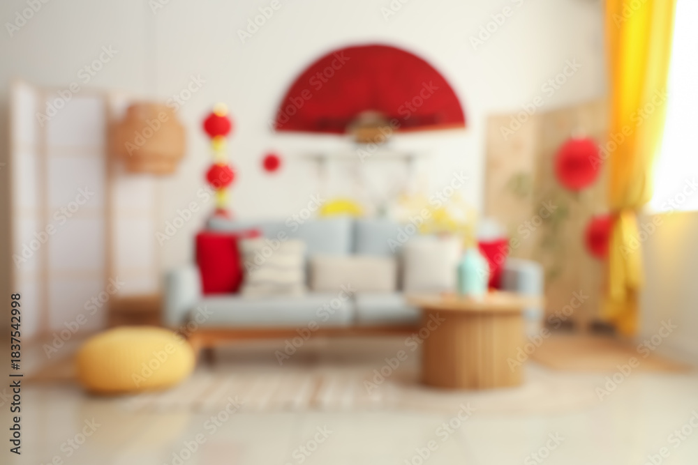 Naklejka premium Blurred view of living room with grey sofa and decorations for Chinese New Year celebration
